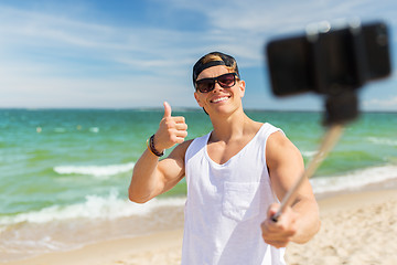 Image showing man with smartphone taking selfie on summer beach