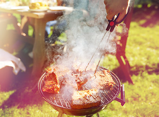 Image showing man cooking meat on barbecue grill at summer party