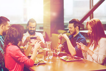 Image showing happy friends taking picture of food at restaurant