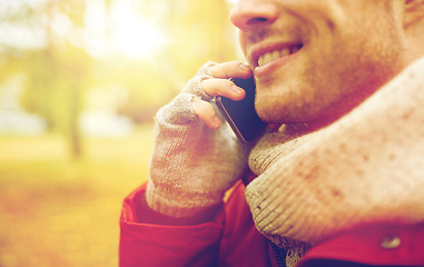 Image showing close up of man with smartphone calling in autumn