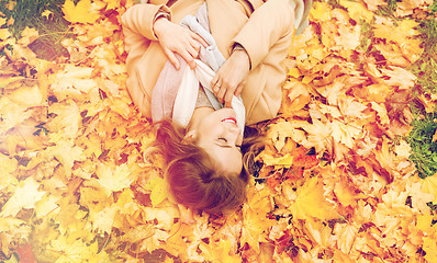 Image showing beautiful happy woman lying on autumn leaves