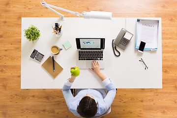 Image showing businesswoman with apple and laptop at office