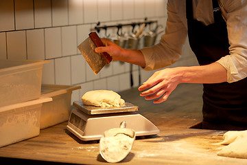 Image showing chef or baker weighing dough on scale at bakery