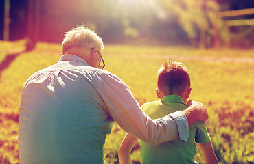 Image showing grandfather and grandson hugging outdoors