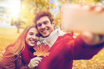 Image showing couple taking selfie by smartphone in autumn park