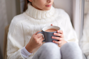 Image showing girl with cacao mug looking at home window