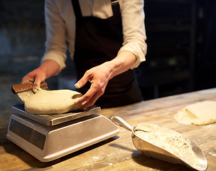 Image showing chef or baker weighing dough on scale at bakery