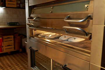 Image showing yeast bread dough in oven at bakery kitchen