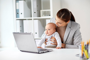 Image showing happy businesswoman with baby and laptop at office