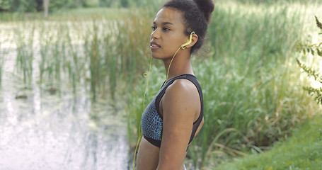 Image showing Dreaming sportswoman posing on lakeside