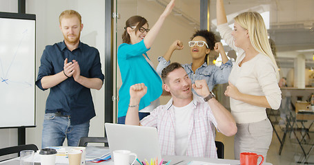 Image showing Coworkers celebrating victory in office
