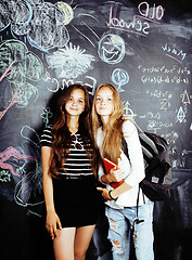 Image showing back to school after summer vacations, two teen real girls in classroom with blackboard painted together, lifestyle people concept