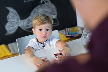 Image showing Cute little toddler boy at speechtherapist session.