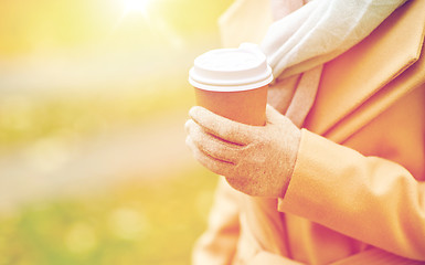 Image showing close up of woman with coffee in autumn park