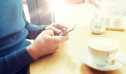 Image showing close up of man with smartphones at cafe