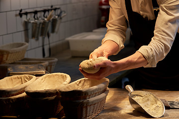 Image showing baker with dough rising in baskets at bakery