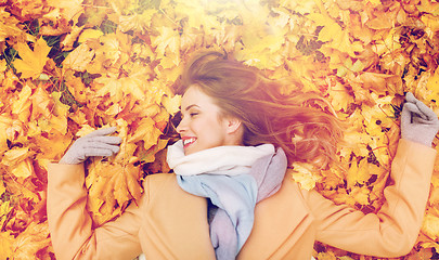 Image showing beautiful happy woman lying on autumn leaves