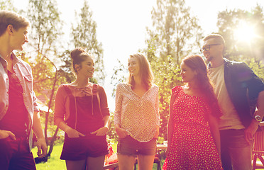 Image showing happy teenage friends talking at summer garden