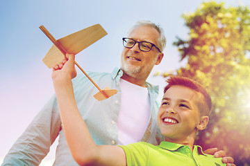 Image showing senior man and boy with toy airplane over sky