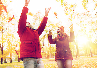 Image showing happy young couple throwing autumn leaves in park