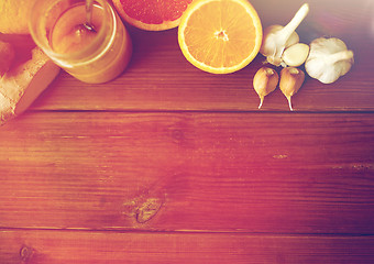 Image showing honey, citrus fruits, ginger and garlic on wood