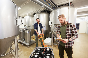 Image showing men with beer kegs on loader at craft brewery