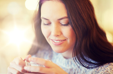 Image showing smiling young woman drinking tea at cafe