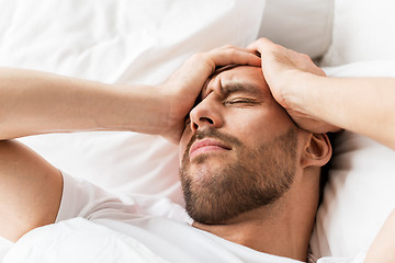 Image showing close up of man in bed suffering from headache