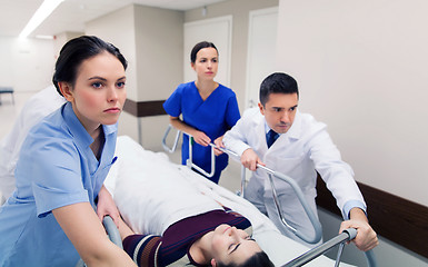 Image showing medics with woman on hospital gurney at emergency