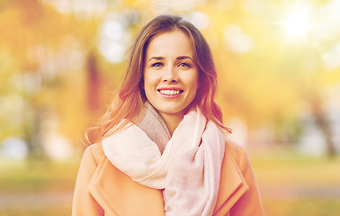 Image showing beautiful happy young woman smiling in autumn park