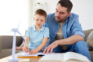 Image showing father and son with toy wind turbine at home