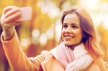 Image showing woman taking selfie by smartphone in autumn park