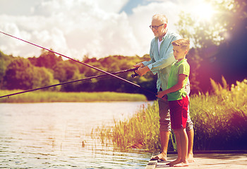 Image showing grandfather and grandson fishing on river berth