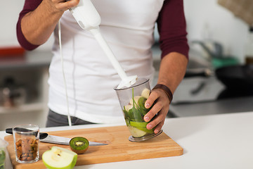 Image showing man with blender and fruit cooking at home kitchen