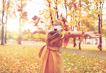 Image showing happy woman having fun with leaves in autumn park