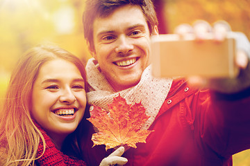 Image showing couple taking selfie by smartphone in autumn park