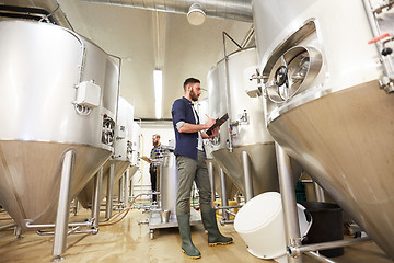 Image showing men with clipboard at craft brewery or beer plant