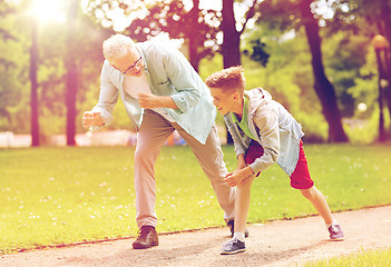 Image showing grandfather and grandson racing at summer park