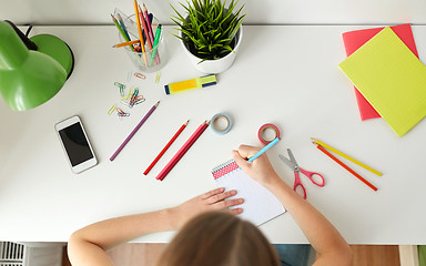 Image showing girl drawing in notebook at home