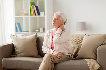 Image showing senior woman suffering from neck pain at home