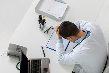 Image showing doctor with cardiogram and laptop at clinic