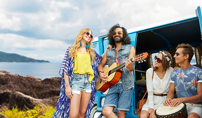 Image showing hippie friends playing music at minivan on island