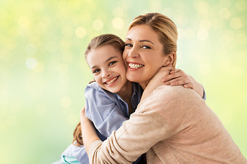 Image showing happy girl with mother hugging over lights