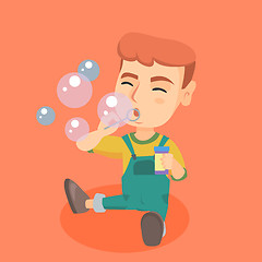 Image showing Little caucasian boy blowing soap bubbles.