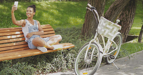 Image showing Cheerful model taking selfie in park