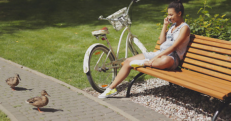 Image showing Woman talking phone on bench