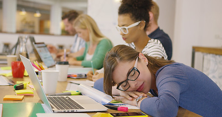 Image showing Employee sleeping at table with coworkers