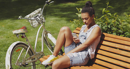 Image showing Youngster with smartphone and bicycle