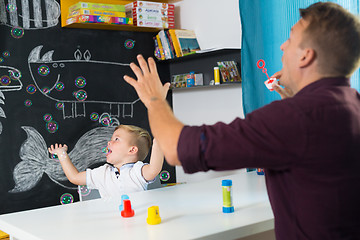 Image showing Cute little toddler boy at speechtherapist session.