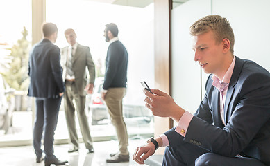 Image showing Businessman using smart phone while sitting in waiting room.